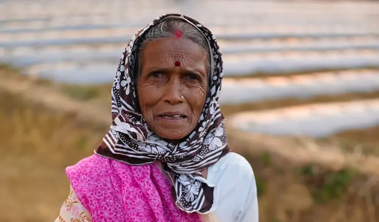 old lady standing in front for her farm